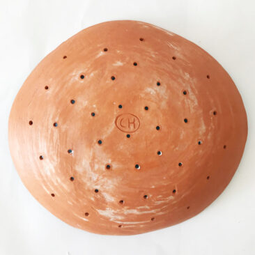 Ceramic bowl with holes in terracotta orange